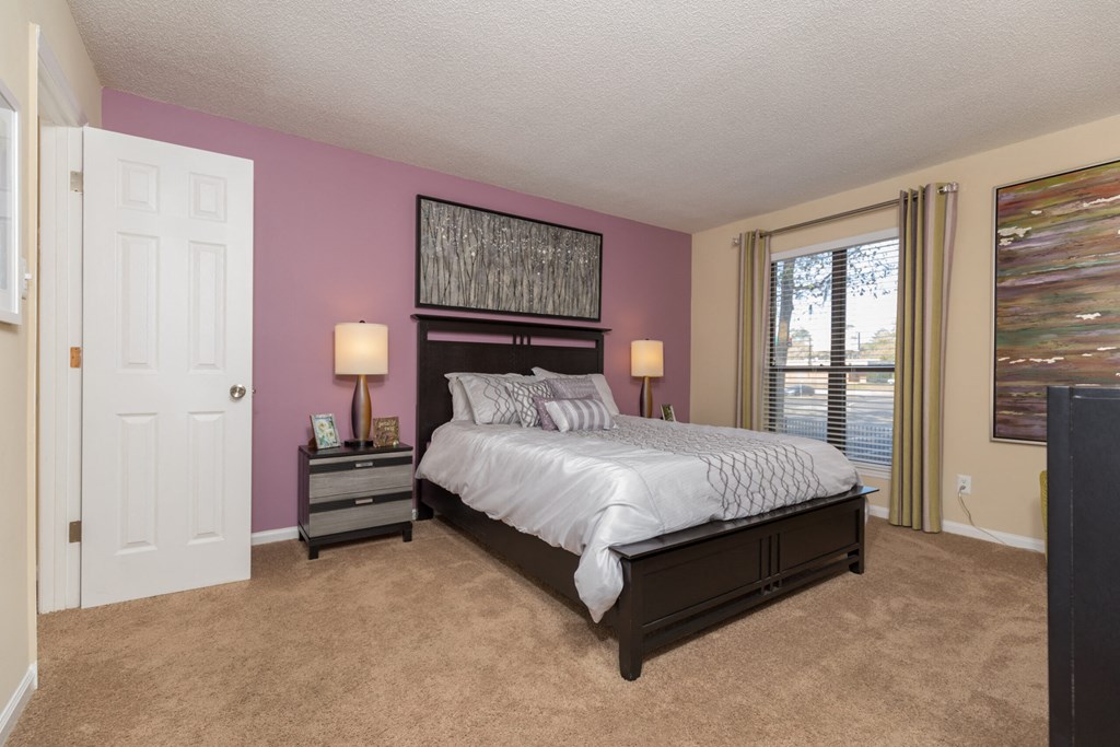 a bedroom with a large bed and a window