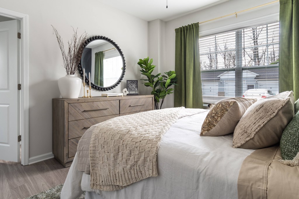 a bedroom with a bed and a dresser with a mirror