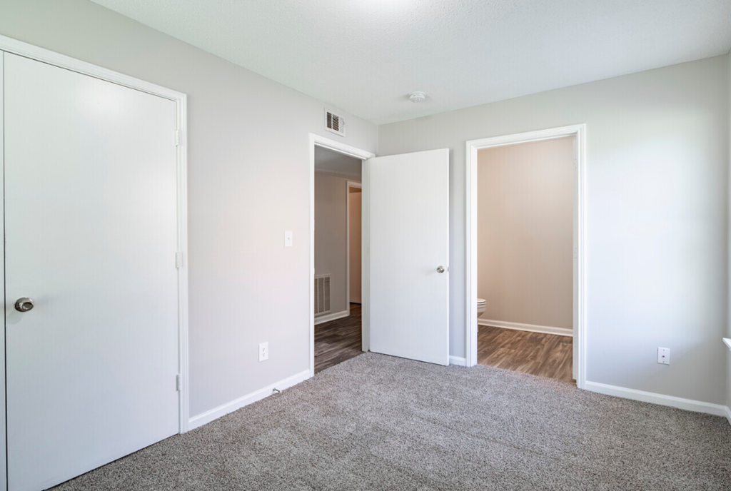 an empty room with white walls and a carpet