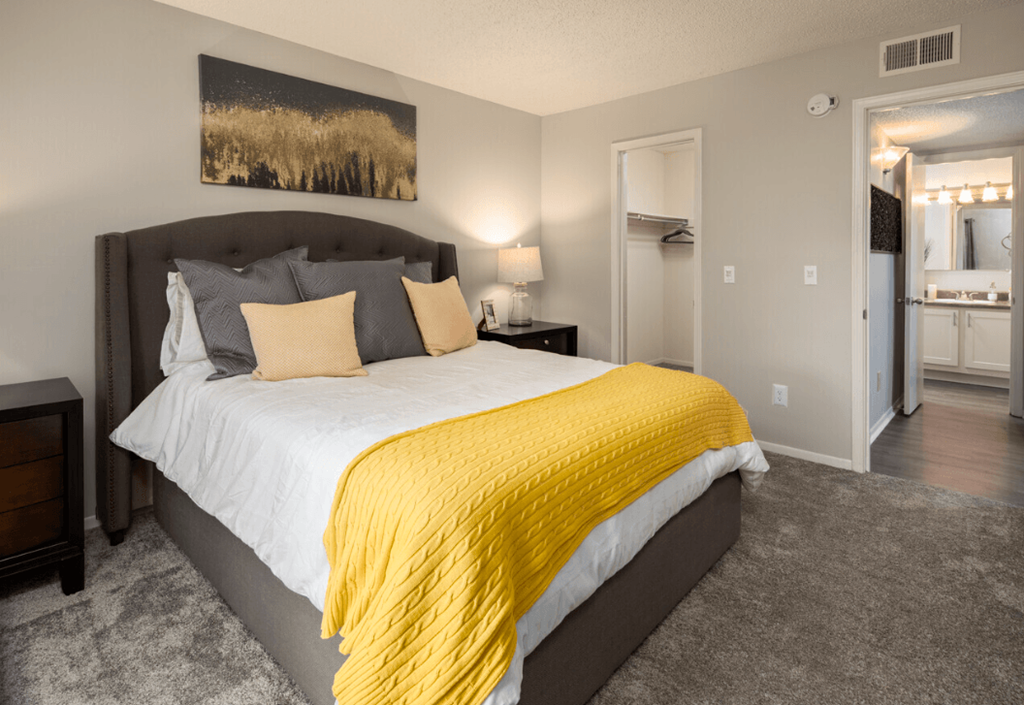 a bedroom with a large bed and a yellow blanket