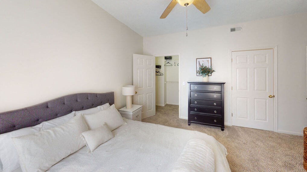 a bedroom with a large bed and a dresser