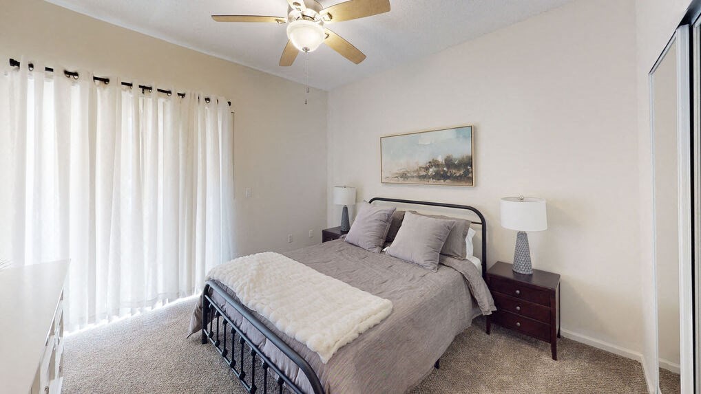 a bedroom with a bed and a ceiling fan