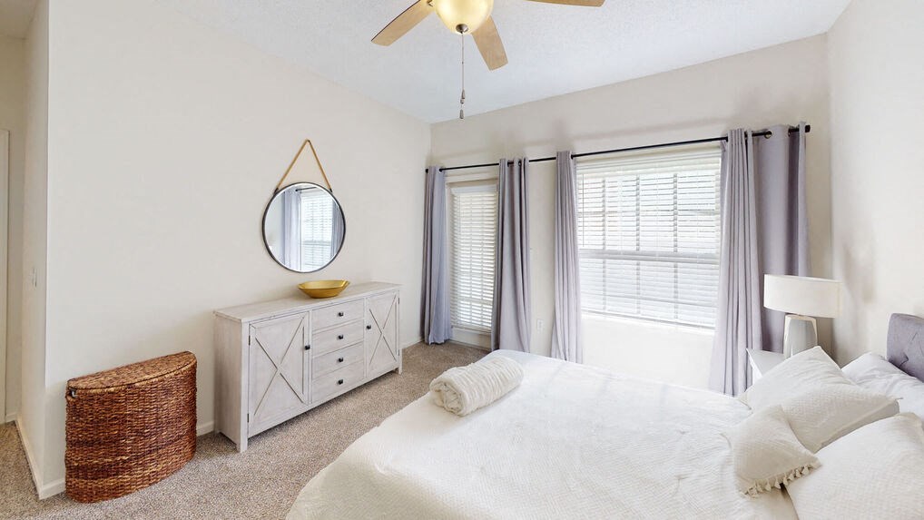 a bedroom with a large bed and a ceiling fan