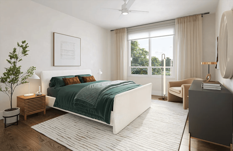 A bedroom with a large bed and a ceiling fan.