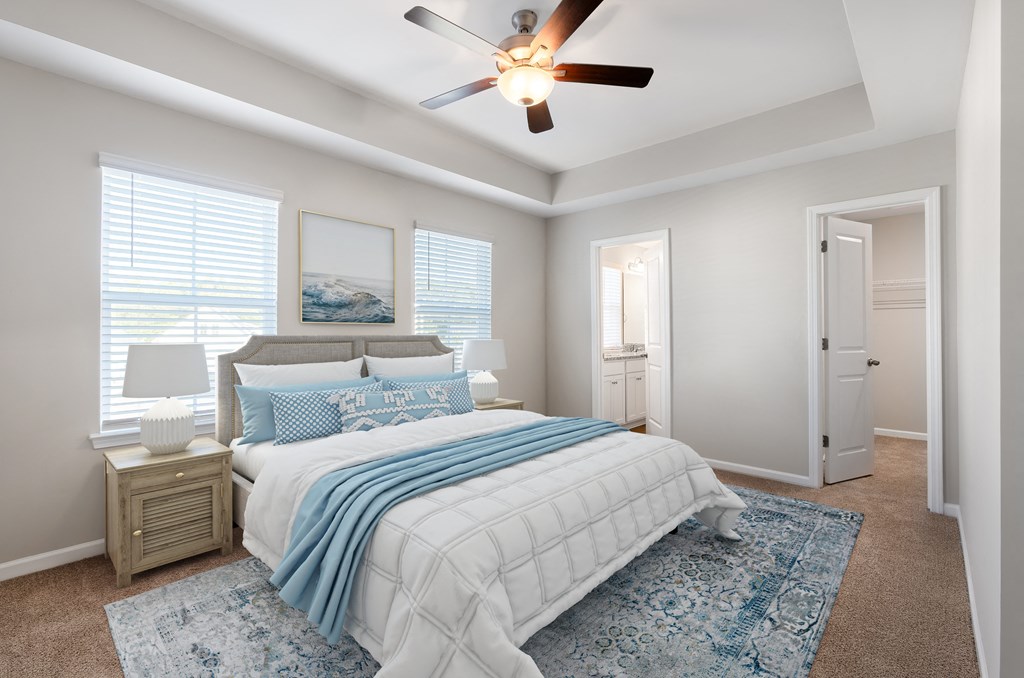 A bedroom with a bed, a ceiling fan, and a rug.