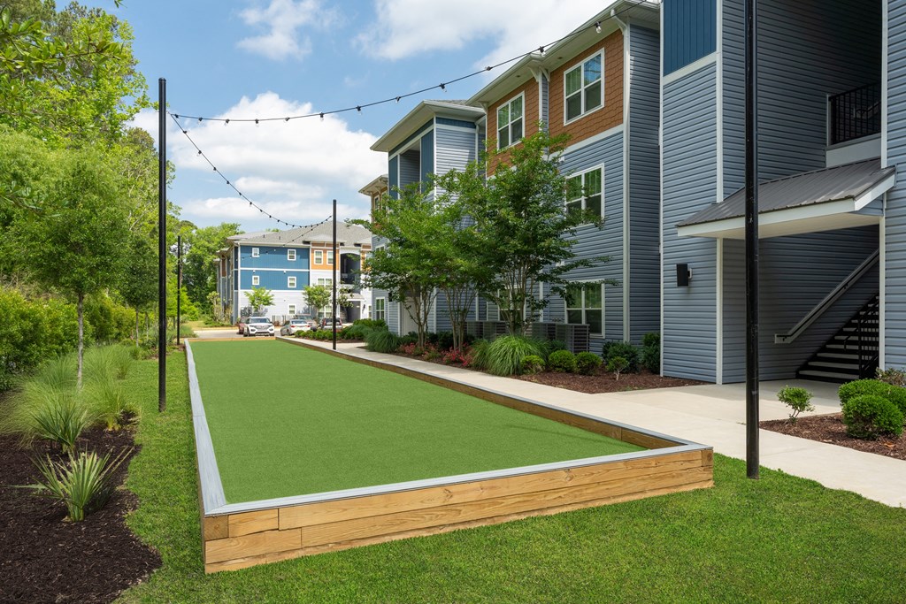 A residential area with a green lawn and apartment buildings.