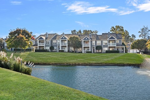 A row of houses with a body of water in front.