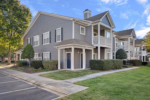 A large grey house with a blue sky in the background.