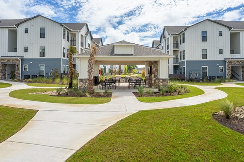 A modern building with a circular walkway in front. at Evolve Holly Ridge Apartments in Holly Ridge, NC