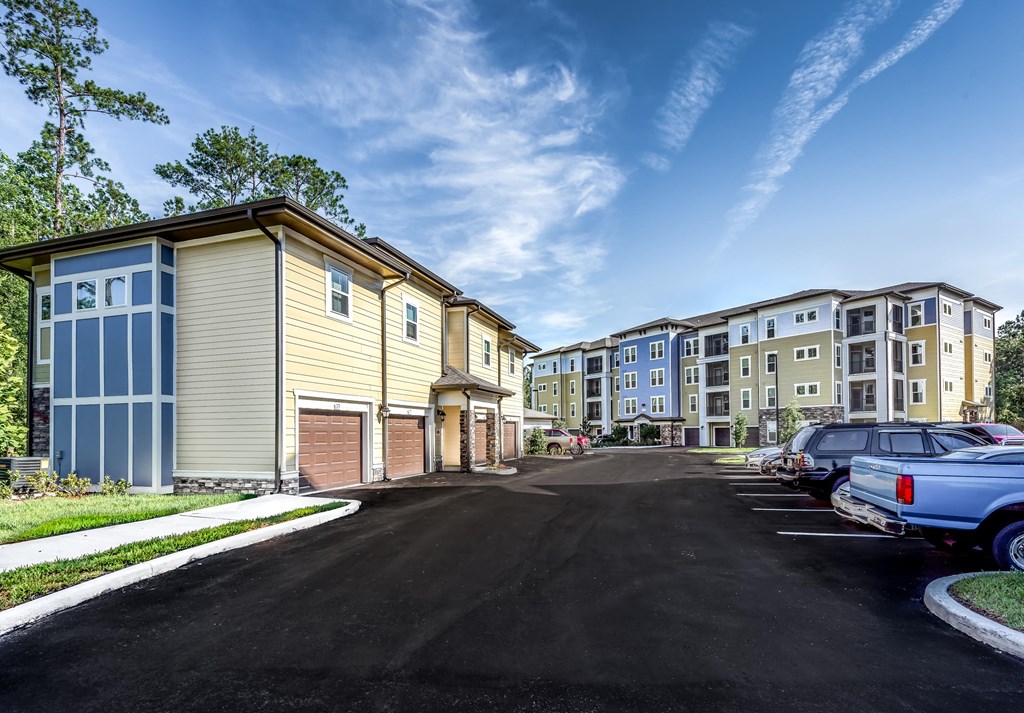 a row of buildings with cars parked in front of them