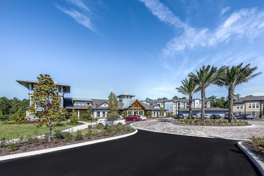a group of houses with palm trees and a road