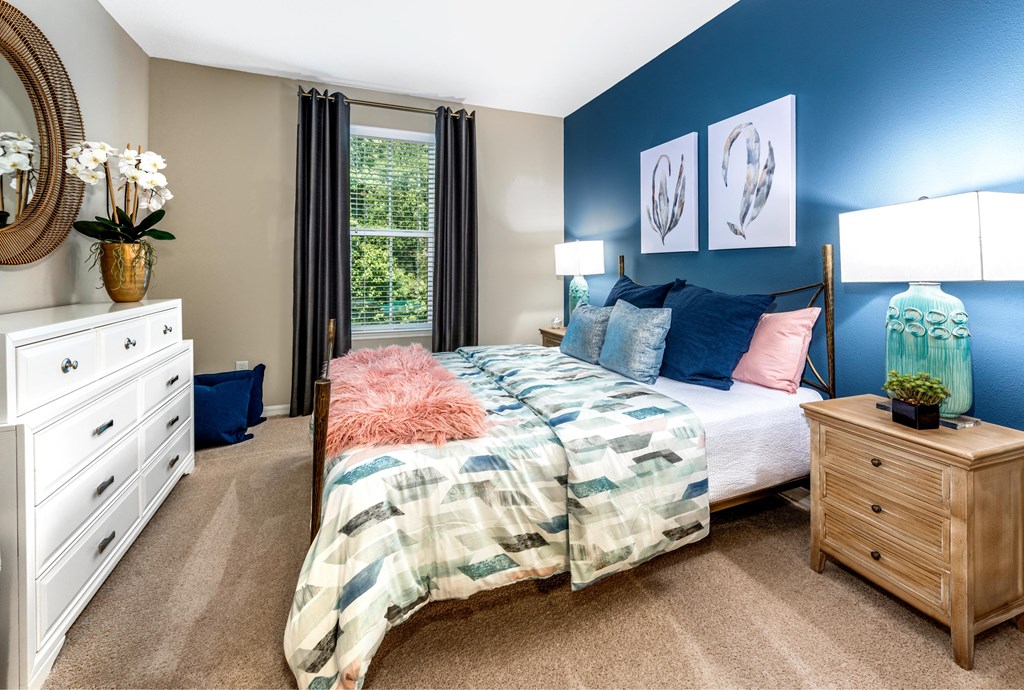 a bedroom with a bed and a dresser and a window