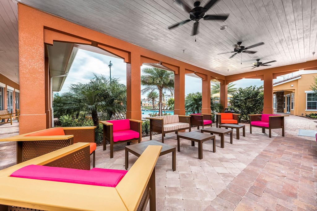 a patio with chairs and tables and a pool