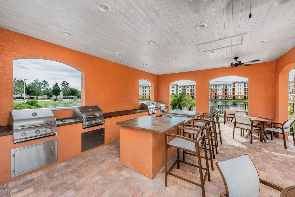 a patio with a bar and tables with chairs