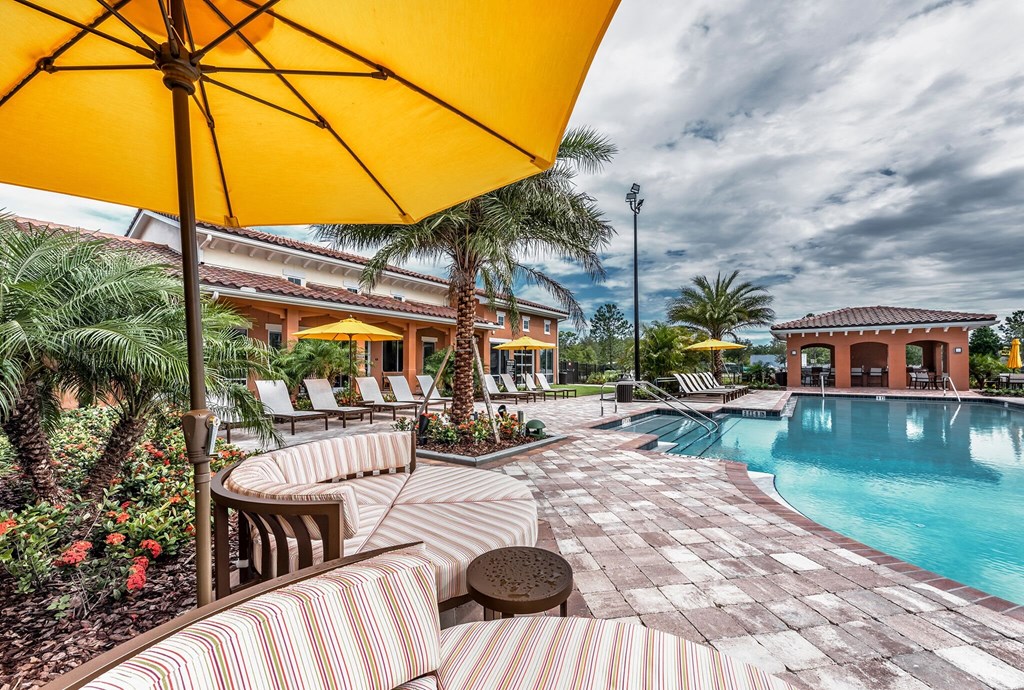 the pool at the club with chairs and umbrellas