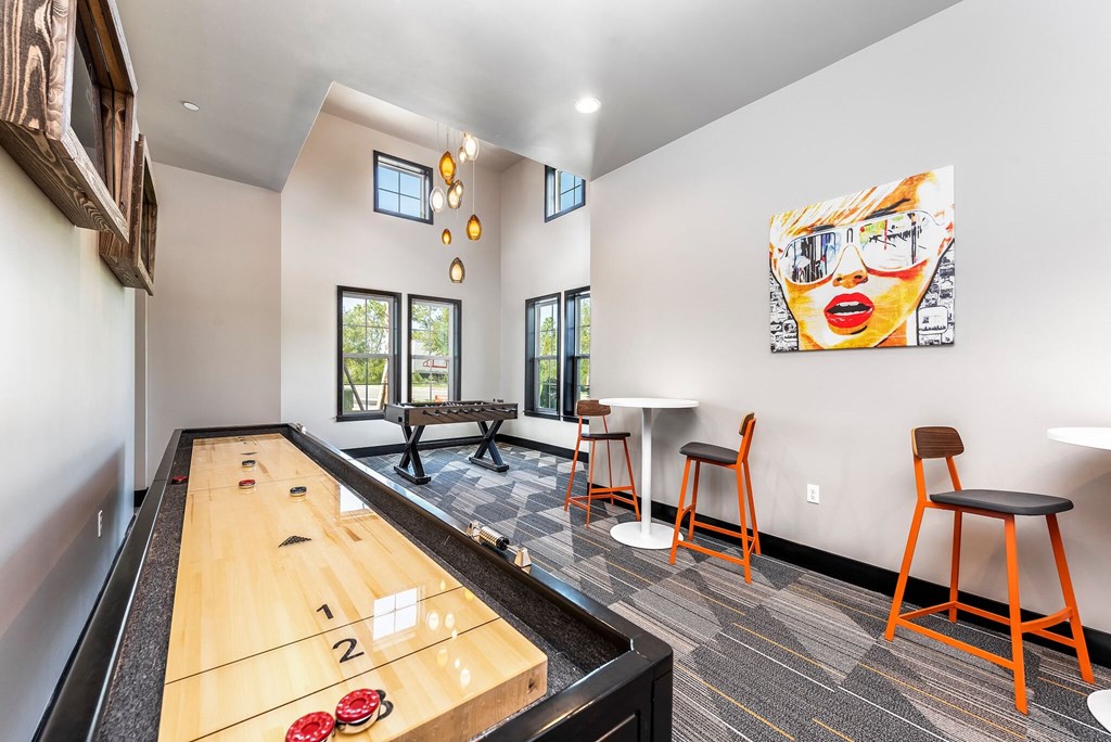 a game room with a ping pong table and a bar with stools