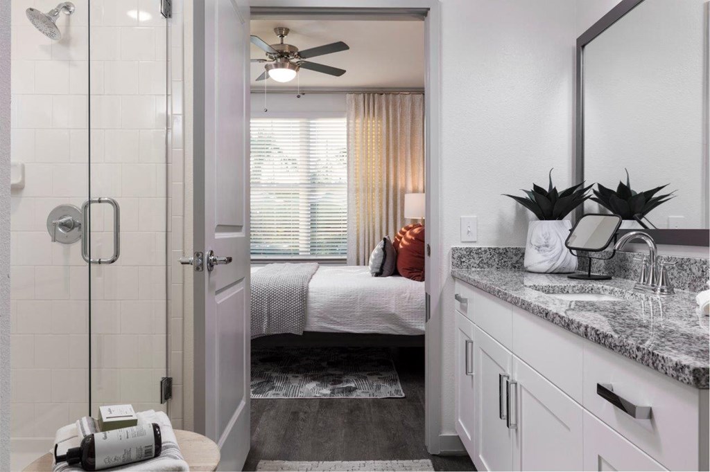 a bathroom with a shower and a bed in a room