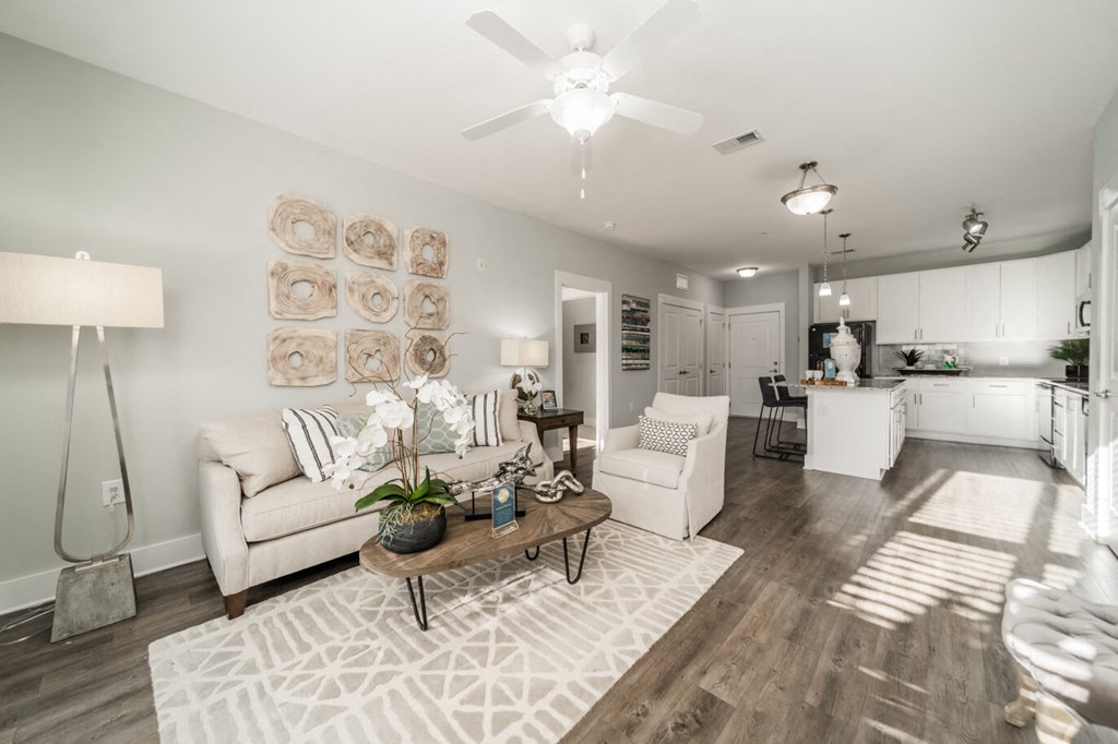 a living room and kitchen with a ceiling fan