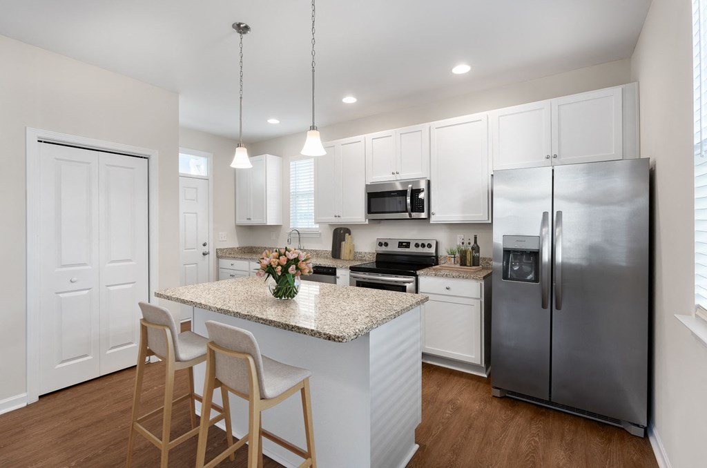 A kitchen with a granite countertop and stainless steel appliances.
