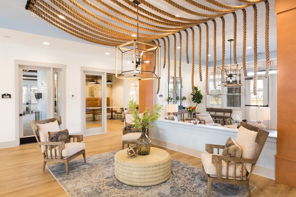 a living room with a round table and chairs and a lobby with a reception area
