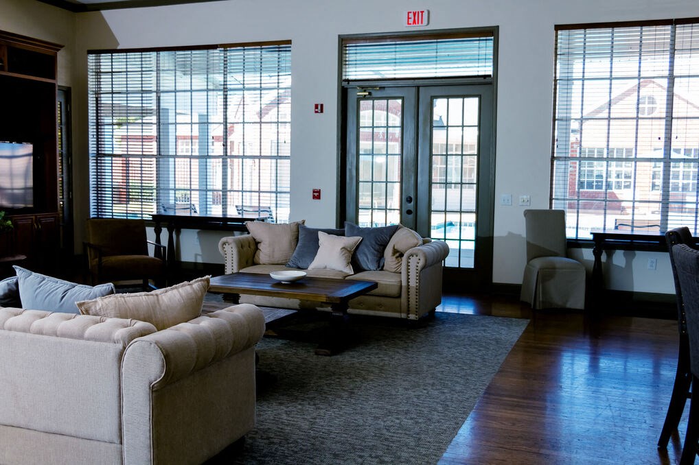 a living room with couches and a coffee table and large windows