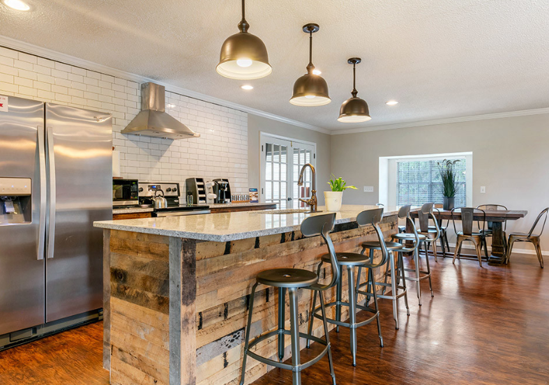 the kitchen has a large island with bar stools and stainless steel appliances