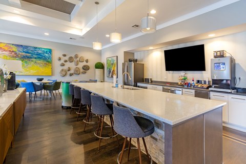 a kitchen with a long counter and chairs in front of a counter top