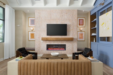A clubhouse with a fireplace and a television above it at Evolve Holly Ridge Apartments in Holly Ridge, NC.