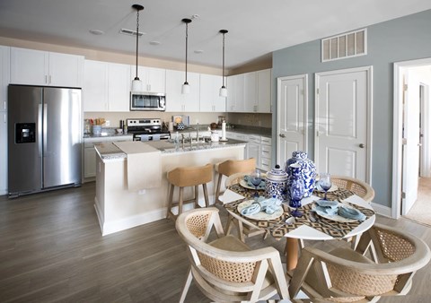 A kitchen with a dining table set for two.