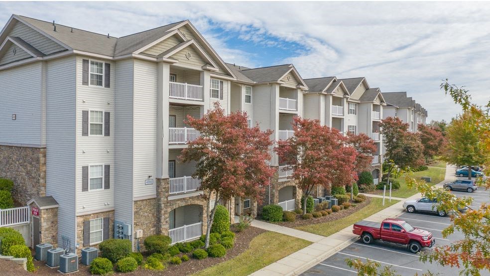 an apartment building with a red truck parked in front of it