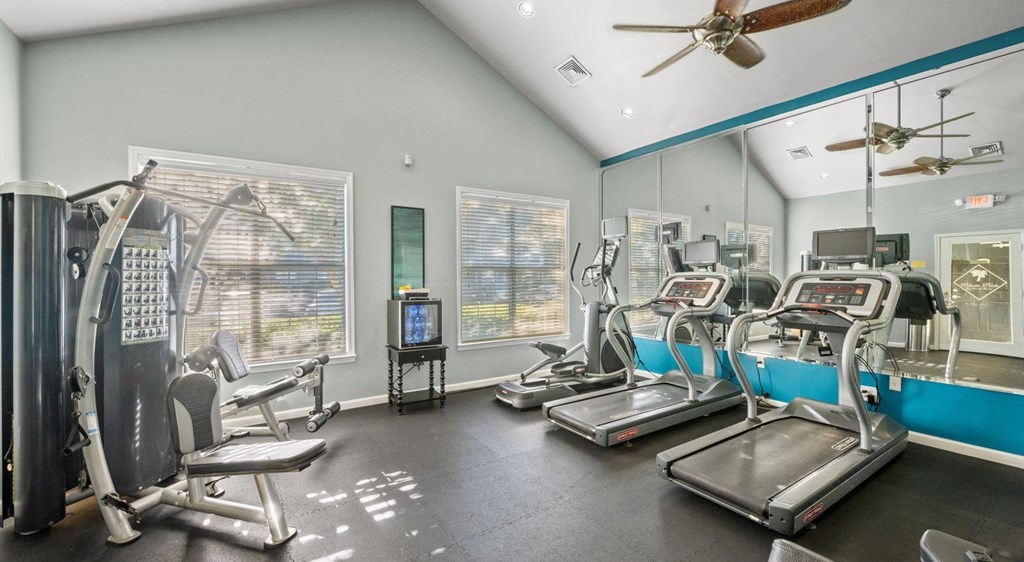 A gym with treadmills, a stationary bike, and a rowing machine at Palmetto Pointe apartments in Myrtle Beach, SC.