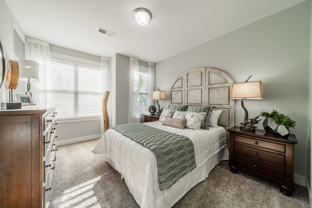 a bedroom with a bed and a dresser and a window