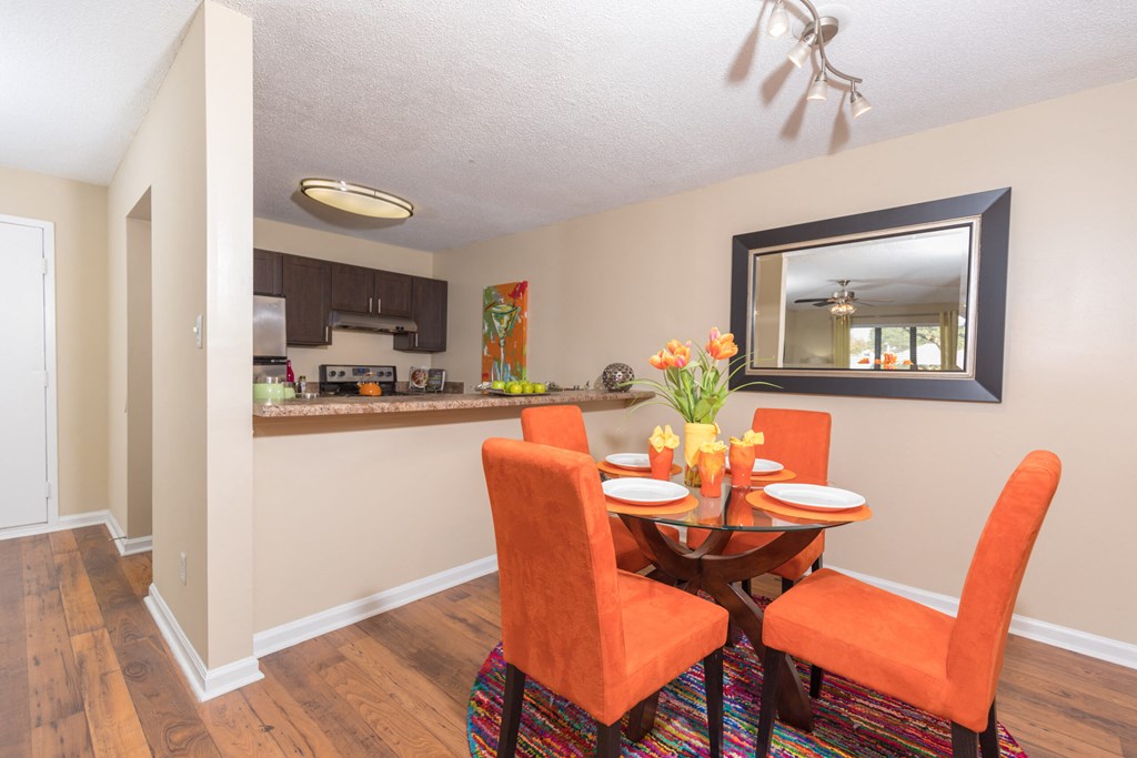 a dining room with a table and chairs next to a kitchen