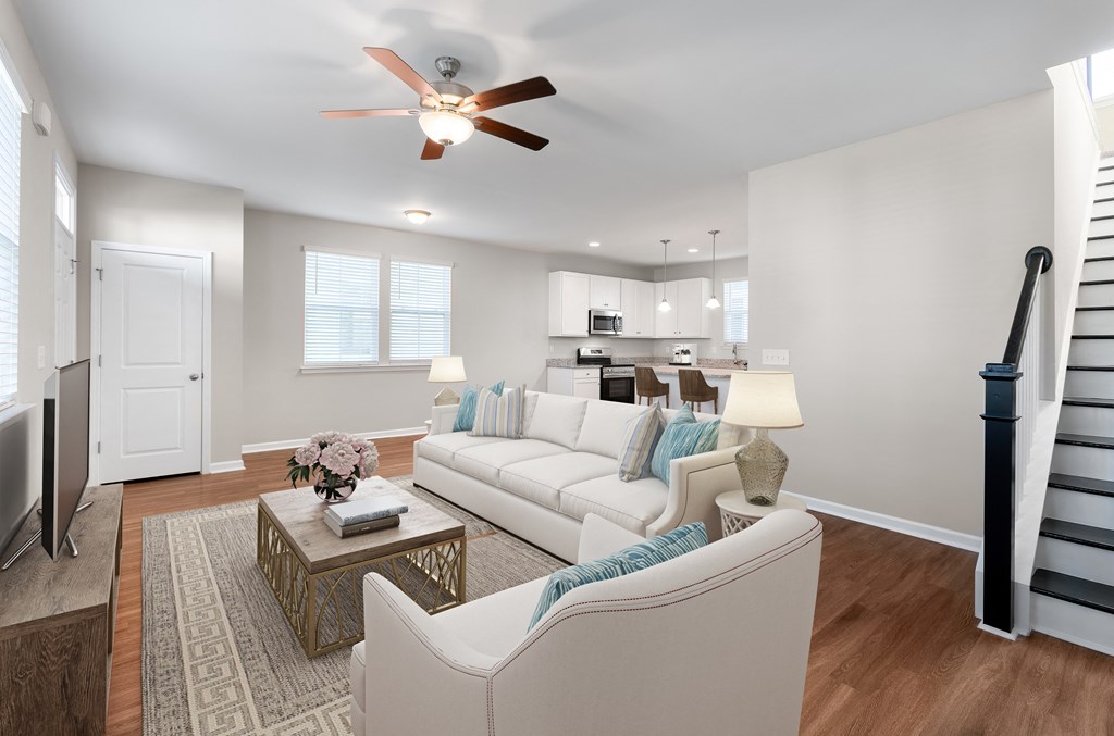 A living room with a white couch, a coffee table, and a ceiling fan.