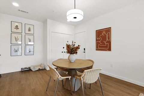 A dining room with a round table and chairs at Terraces at High Mountain apartments in Huntsville, AL.
