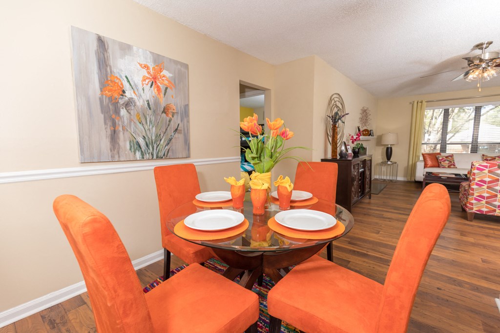 a dining room with orange chairs and a dining table