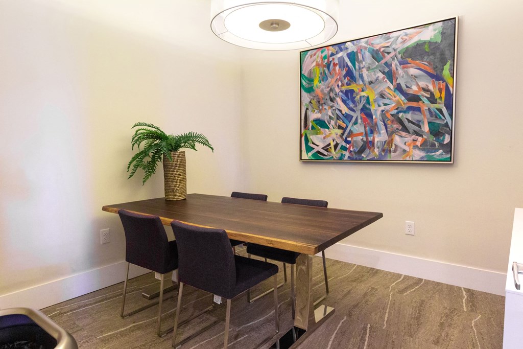 a dining room with a table and chairs and a painting on the wall