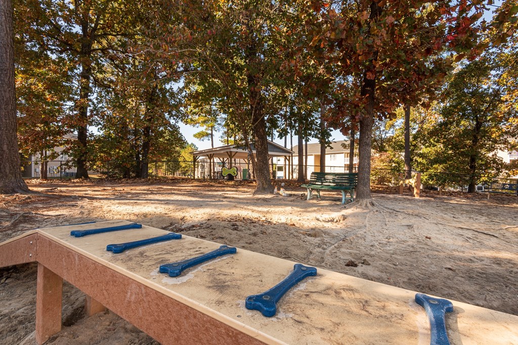 A sandbox with blue slides in the middle of a park.