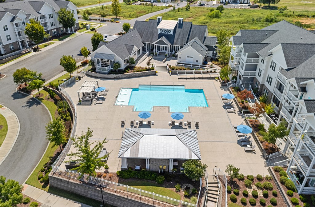an aerial view of a large swimming pool in front of a row of houses