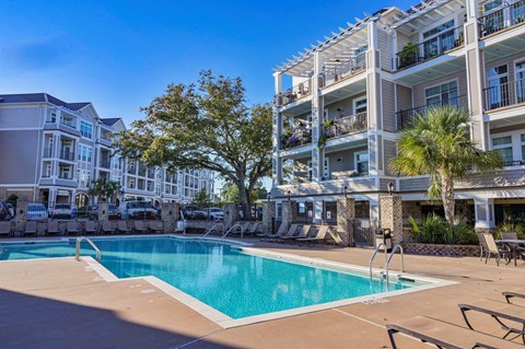 A large swimming pool in front of apartment buildings.