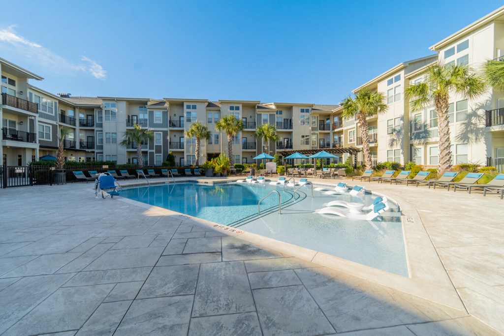 a swimming pool with an apartment building in the background