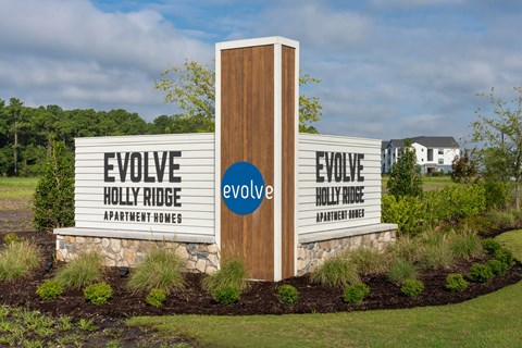 A sign for Evolve Holly Ridge Apartment Homes is displayed