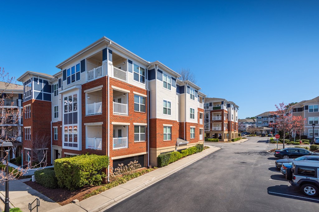 an apartment building on a city street with a parking lot