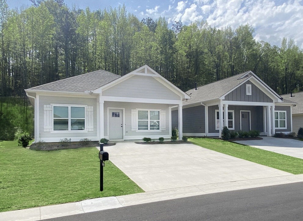 a white and gray house with a driveway and lawn