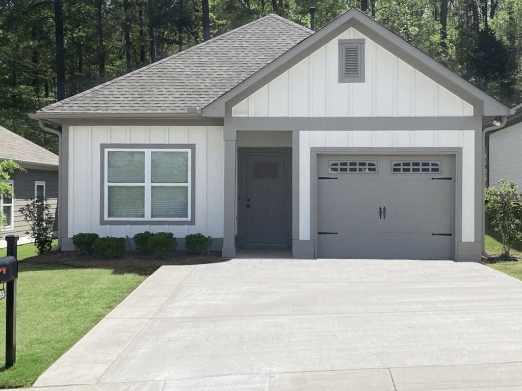 a white house with two garage doors and a driveway