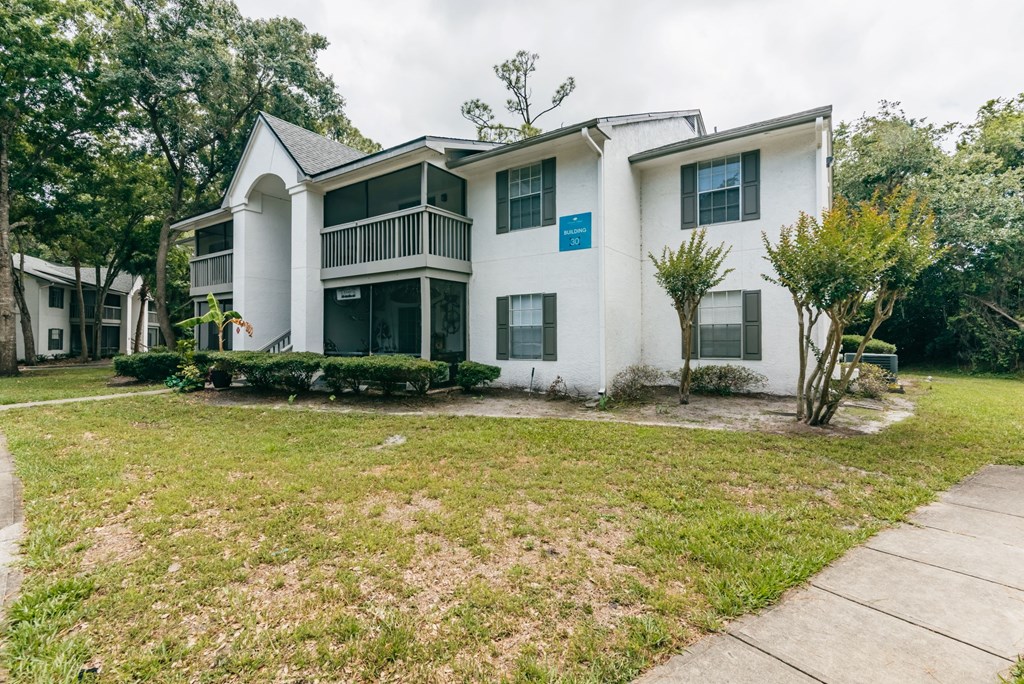 a white house with a yard and a sidewalk