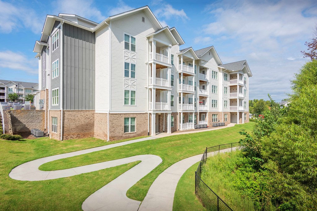 an exterior view of an apartment building with a walkway in front of it