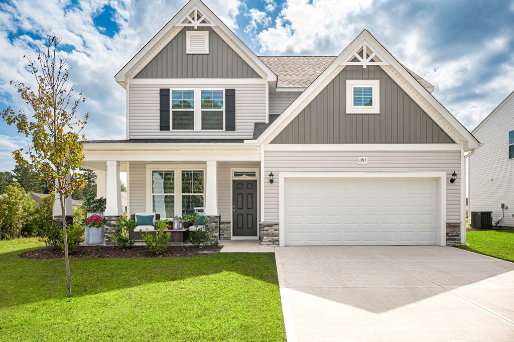 a white house with a garage door and a lawn