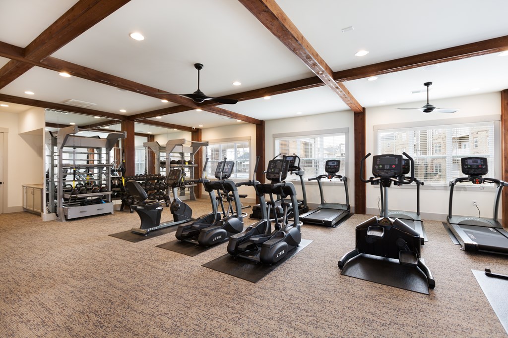 A gym with treadmills, elliptical machines, and other exercise equipment.