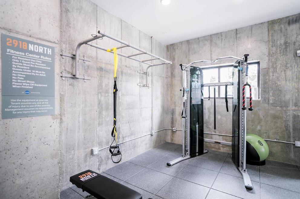 a gym with weights and other equipment in a room with concrete walls